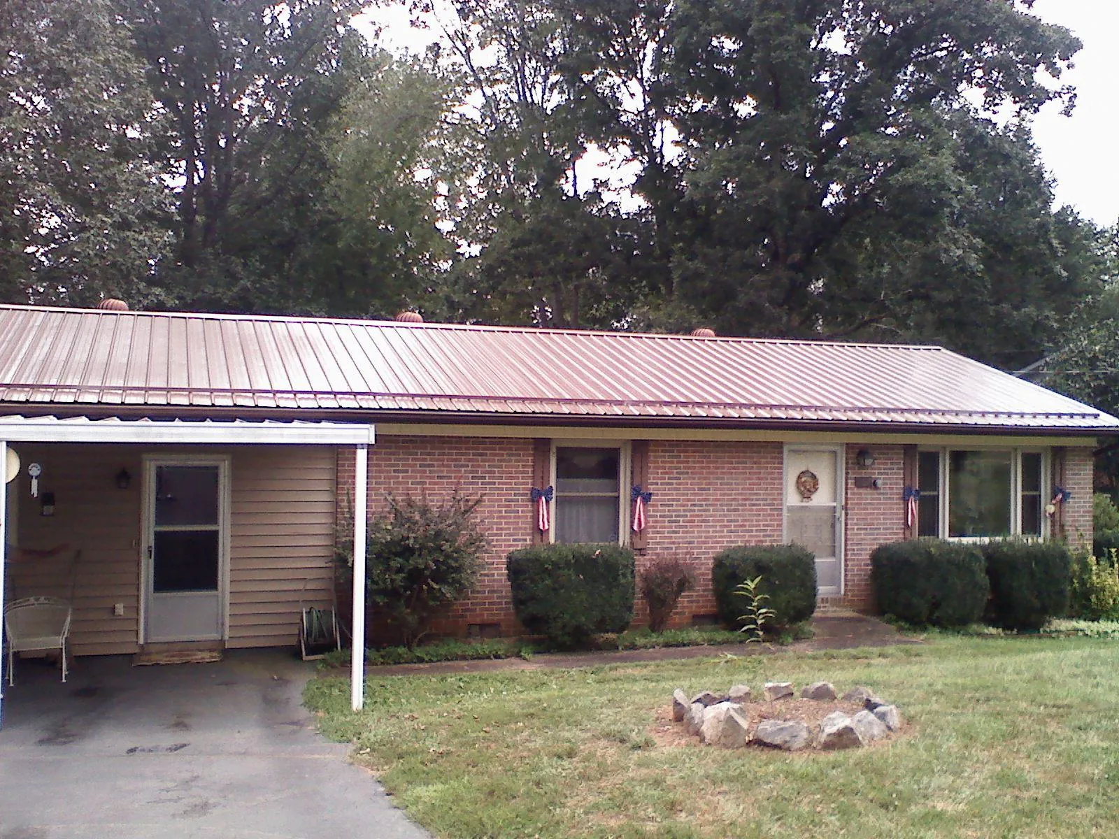 Bronze metal roof and carport on a brick ranch home — Roof Repair work by our crew in Fleetwood
